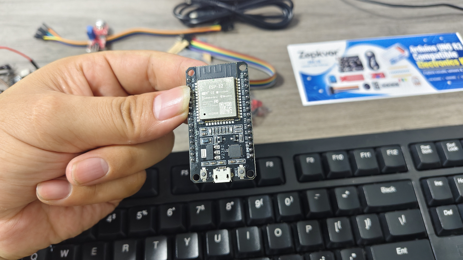 ESP32 development board held in hand, showing the module, GPIO labels and Micro-USB connector